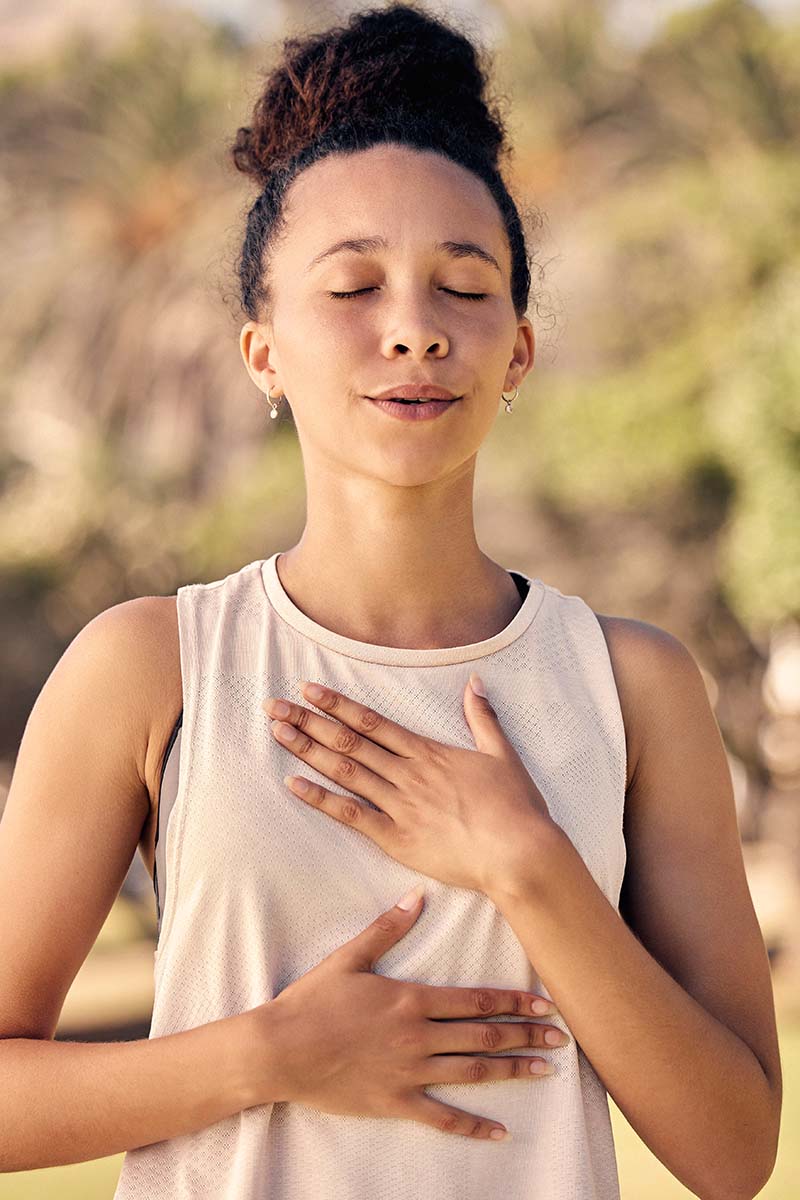 Frau mit geschlossenen Augen macht achtsame Atemübungen