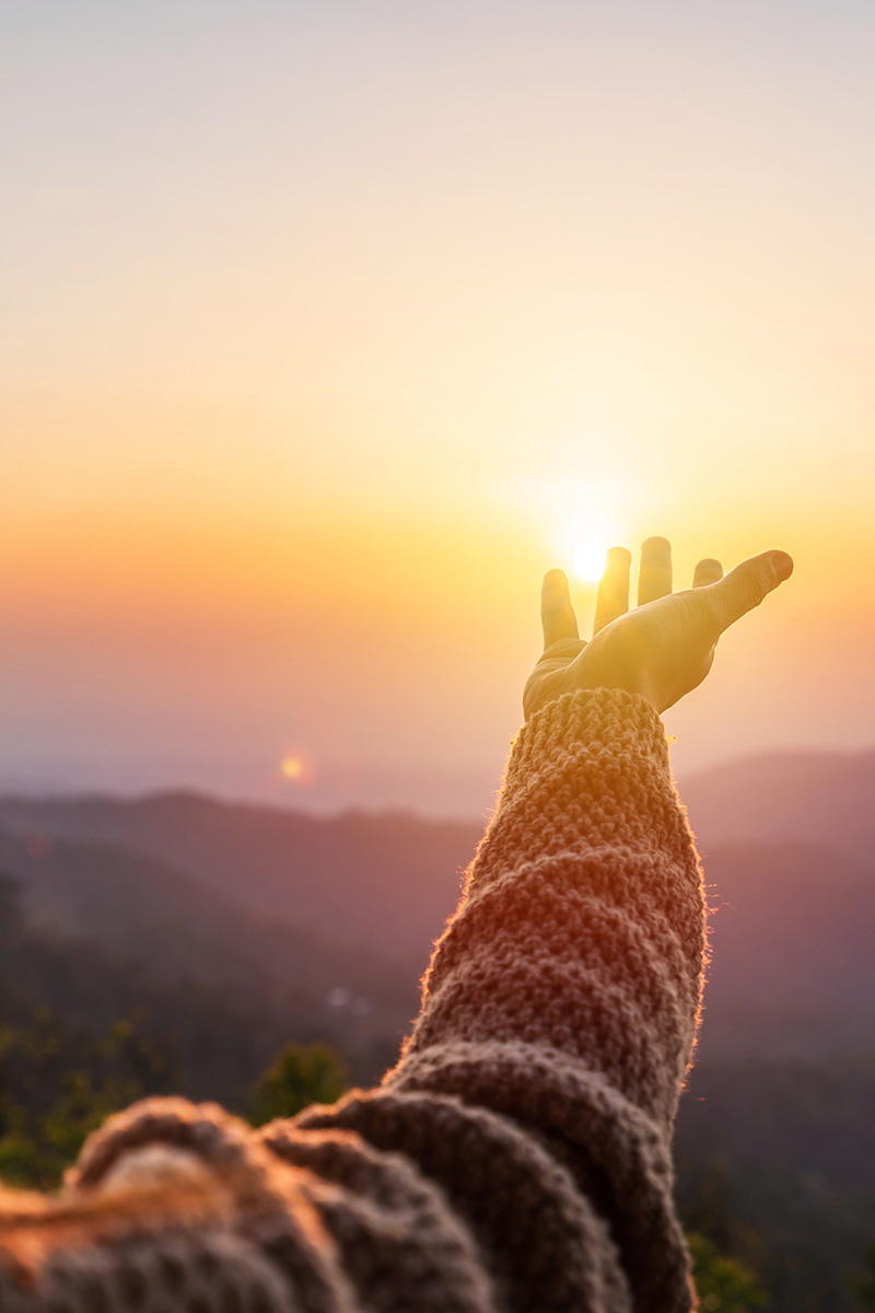 Hand greift nach Sonne