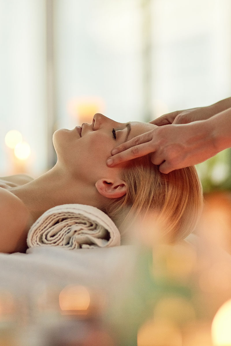 Kopfmassage an den Schläfen einer Frau