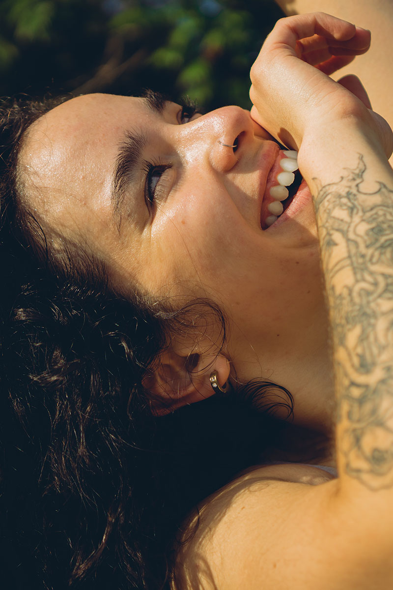 Lachende Frau mit Tattoo auf dem Arm